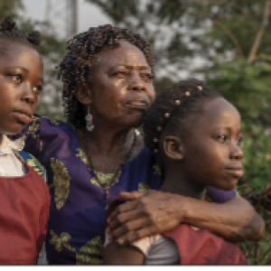 Woman and with her arms around her two daughters