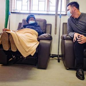 Alejandro Nava from the Rutgers Institute speaks with cancer patient at Senkata Oncology clinic.