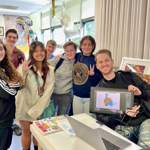 6 students standing next to a Nickelodeon volunteer displaying a drawing tablet
