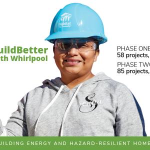 A person in a blue hard hat, protective eye ware and gloves holding a piece of lumber. "BuildBetter with Whirlpool" on the left. "Phase One: 58 projects, 20 US States Phase Two: 85 projects, 31 US states" on the right and "Building energy and hazard-resilient homes" on the bottom.