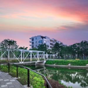 Bridge over water set before apartments at sunset