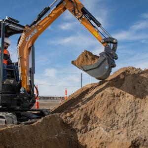 CX25EV electrified mini excavator lifting dirt