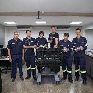 Six people stood in a room posing for a photo 