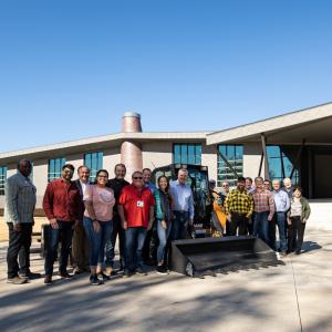 People gathered around a tractor being donated