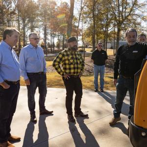People gathered around a tractor being donated