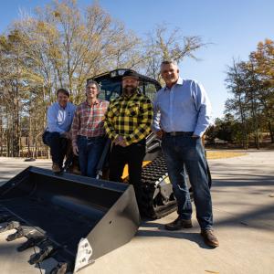 People gathered around a tractor being donated