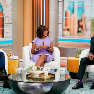 Three people in chairs on a news segment.
