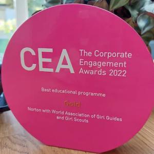 CEA Award. Pink, circular, with white writing "The Corporate Engagement Awards 2022.Best educational programme Gold"