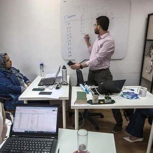 people working with one writing on a whiteboard