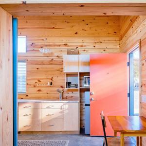 interior of a tiny home with wood planks on the walls and a small table and chair.