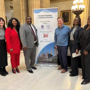 Representatives from the City of Cleveland and KeyBank shown in front of the Cleveland Housing banner.