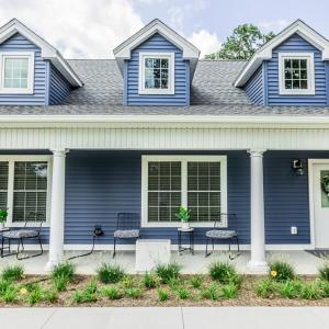 The exterior of a blue house is shown.