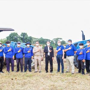 Group of people posing in front of two tractors