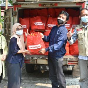 4 people standing in front of a truck filled with Red Lenovo bags