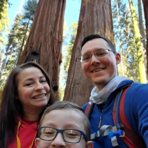 Calvin, his wife and son in a forest.