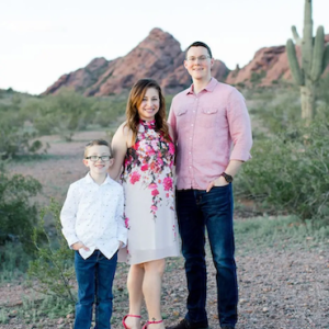 Calvin, his wife and son in the desert with a cactus in the background.