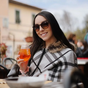 Camila on vacation sipping a drink.