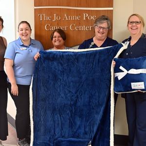 A group of people at the Jo Anne Poe Cancer Center holding a blanket