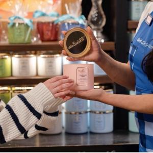Bath & Body Works employee showing a candle to a customer