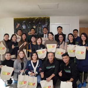 Group of people holding Herbalife Nutrition Foundation tote bags