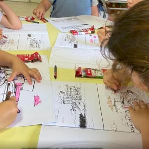 Children coloring in pictures of tractors