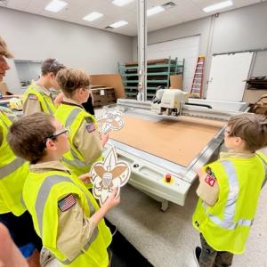 Children wearing hi-vis vests inside a manufacturing facility 
