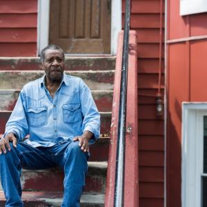 Resident seated in front of his home in NYC.