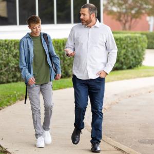 Father and son walking and having a conversation.
