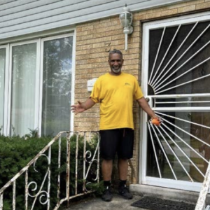 Derek shown in front of his family home.