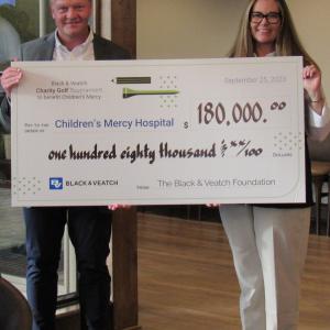 Dr. Tomi Pastinen, director of the Genomic Medical Center at Children’s Mercy Hospital, accepts a $180,000 Black & Veatch contribution from Katie Werner, Black & Veatch chief of staff, on Monday, Sept. 25, 2023. Those proceeds from the company’s charity golf tournament in Olathe, Kansas, brings to more than $5 million the amount Black & Veatch has contributed to Children’s Mercy over the past 27 years. 