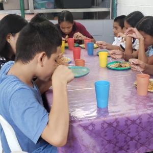 Children sat at table eating food