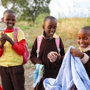 Children smiling while holding different objects