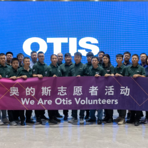 Otis China volunteer tutors holding banner