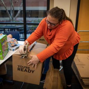 woman taping up a box