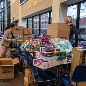group putting toys in boxes