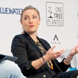 Claire Poole seated on stage, speaking to the others