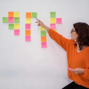 Clara Avila in front of a wall with colored post it notes.