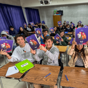Classroom of students holding up notebooks