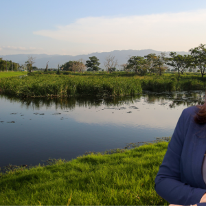Headshot of Claudia Sandoval against a water and trees backdrop