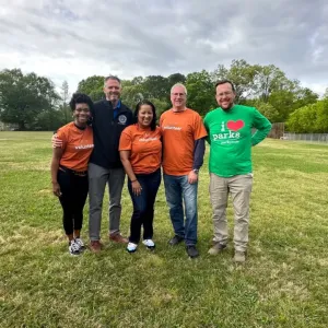 A group of volunteers stood together in a field smiling