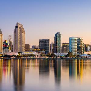 Cityscape shown in reflection of water.