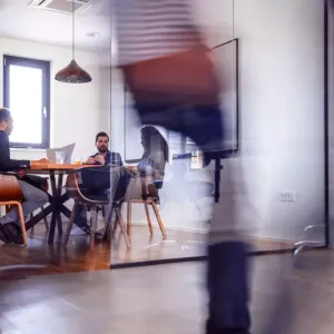 Three people sat around a table in an office