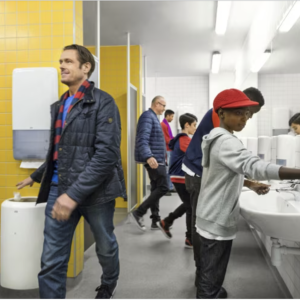 People in a public bathroom using Tork's new hygiene products to wash their hands