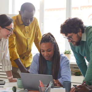 Volunteers collaborating around a computer 