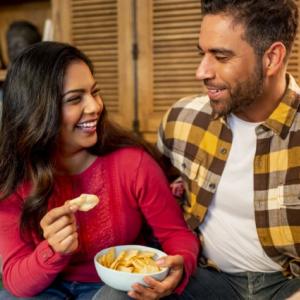couple snacking on a couch