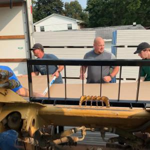 Men unloading wallboard from a truck
