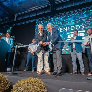 2 people cut a ribbon on stage