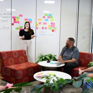 People talking together in front of a whiteboard