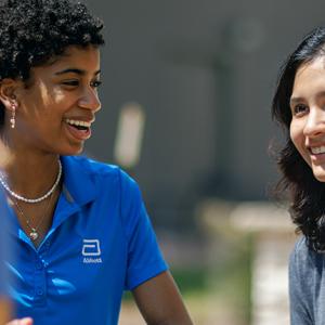 two smiling people wearing shirts with the Abbott logo
