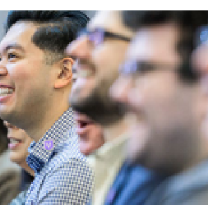 A row of smiling people, focused on one in the middle.